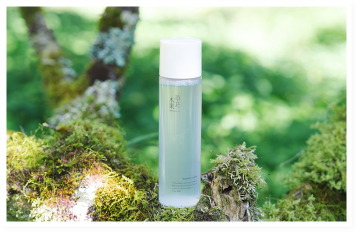 木の上に置かれた草花木果エッセンスローション